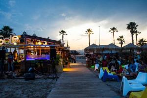 卡斯特利翁-德拉普拉纳Villa Holiday的海滩上的酒吧,人们坐在椅子上