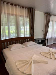 通奈潘海滩布达拉克撒旅馆的一张白色的大床,上面有毛巾