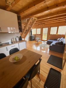 莫克拉戈拉Apartman Lenka的厨房以及带木桌的起居室。
