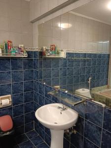 奥隆阿波ARIZONA BEACH RESORT的蓝色瓷砖浴室设有水槽和镜子