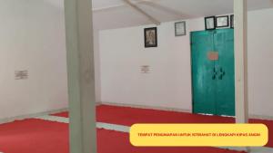 TubanAstana Kidul Masjid的一间设有绿门和红色地板的客房