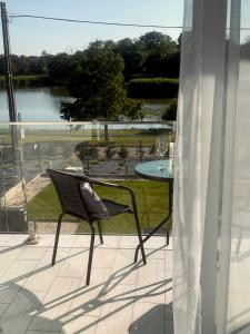 欧罗什哈佐Lux apartments的湖景阳台的椅子