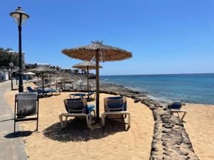 普拉亚布兰卡Villa Burgao的海滩上的一组椅子和一把遮阳伞