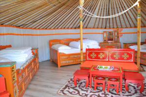 PaluelRando-Yourte的圆顶帐篷内带两张床和一张桌子的房间