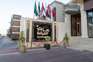 塔伊夫Ramz Al Diyafa 1的商店前有旗帜的建筑物