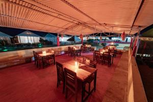 斋沙默尔Shama Desert Luxury Camp & Resort的餐厅设有木桌和椅子及灯光