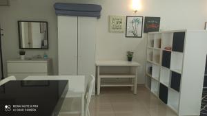 哥打巴鲁Zulanie Studio at D'Perdana Apartment, Spacious and Cozy Studio with POOL, Free Wifi & Netflix的客房设有书桌、桌子和镜子