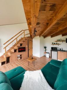 布泽乌Stuf by NorAtlas Heritage - Adults Only的客厅设有绿色沙发和楼梯。