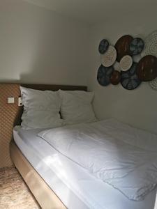 斯图加特Akteon Hotel的一张墙上有白色床单和盘子的床