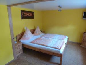 灵斯海姆里萨贝私人民宿的卧室配有一张床铺,位于一个黄色墙壁的房间