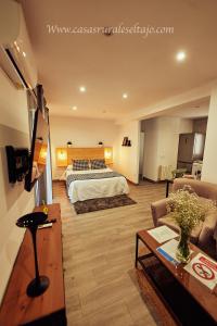 塞特尼尔Casas Rurales El Tajo的酒店客房设有床和客厅。