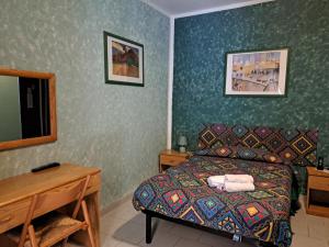 法纳诺hotel Bologna的一间卧室配有一张床、一张桌子和一面镜子