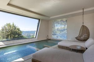 皮加罗I Borghi dell'Eremo的客厅设有一座带大窗户的游泳池