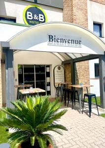 热姆诺B&B HOTEL Aubagne Gémenos的大楼前设有桌椅的餐厅