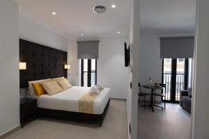 瓦伦西亚Suites Puerto Valencia的一间卧室配有一张床,另一间卧室配有桌子