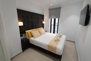 瓦伦西亚Suites Puerto Valencia的一间卧室配有一张大床和黑色床头板
