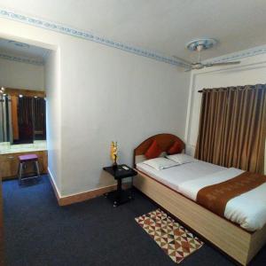 加尔各答Tulip 1bhk Apartment by Hotel Airways的一间卧室配有一张床、一张桌子和一个窗户。