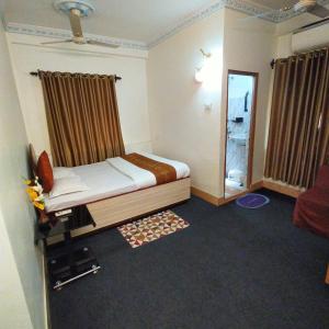 加尔各答Tulip 1bhk Apartment by Hotel Airways的一间小卧室,配有一张床和镜子