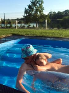 欧罗什哈佐Lux apartments的游泳池里的男人和孩子