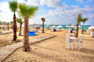 亚历山大天堂海滩度假酒店的棕榈树海滩,桌椅