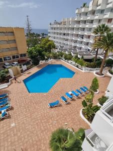 法纳贝海滩Stonefall Tenerife Holiday Apartment Las Americas的一个带躺椅的大型游泳池和一间酒店