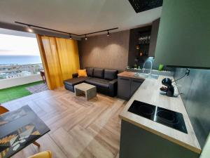 法纳贝海滩Stonefall Tenerife Holiday Apartment Las Americas的厨房以及带沙发的起居室。