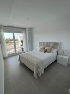 瓦伦西亚Apartamento luxury frente al mar的白色的卧室设有一张大床和一个大窗户
