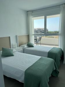 瓦伦西亚Apartamento luxury frente al mar的带大窗户的客房内的两张床