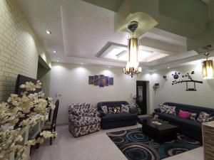 Sheikh Zayed2 bedroom, 4 beds, apartment in El sheikh Zayed Cairo Egypt的带沙发和吊灯的客厅