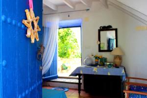 AlbuñolLa Casita Azul - Casa típica andaluza的一间设有一张桌子和一扇窗户的蓝色门的房间