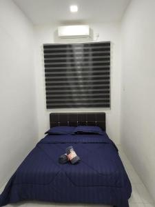 瓜拉立卑Hud D'Lipis Homestay的一间卧室配有一张带蓝色棉被的床和窗户。