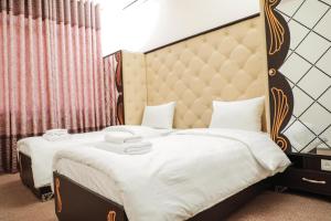 苦盏Khujand Star的一间卧室配有一张大床和软垫床头板