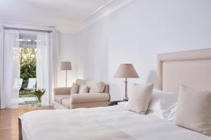 斯派赛斯波塞冬尼大酒店的白色卧室配有床和椅子