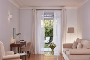 斯派赛斯波塞冬尼大酒店的带沙发、书桌和窗户的客厅