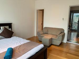 马尼拉Century Properties/ Aqua Iguazo Condo Unit的一间卧室配有一张床、一张沙发和一把椅子