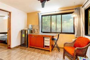 达波林The Burrow in South Goa.的客房设有书桌、椅子和窗户。