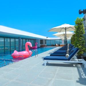 麦纳麦巴林格罗夫酒店及会议中心的一个带充气天鹅和遮阳伞的游泳池