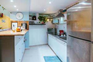 特拉维夫Jabitat- Jaffa Boutique TLV的厨房配有白色橱柜和不锈钢冰箱