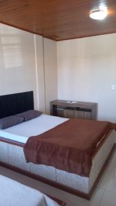 马卡埃Pousada GPC的一间卧室配有一张大床和一张书桌