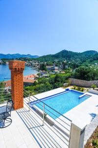 洛帕德Boutique Hotel Tomić的享有水景的阳台的游泳池
