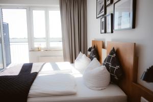 埃默里希Hotel Rheinpromenade8的一间卧室配有带白色床单和枕头的床。