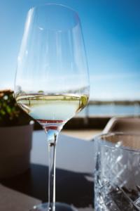 埃默里希Hotel Rheinpromenade8的坐在桌子上的一杯白葡萄酒