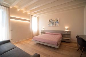维罗纳Calcirelli Suites的一间卧室配有一张床、一张桌子和一张沙发