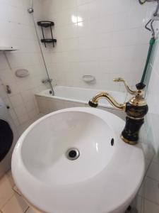 迪拜Cloud9 Premium Hostel的浴室配有带金色水龙头的白色水槽