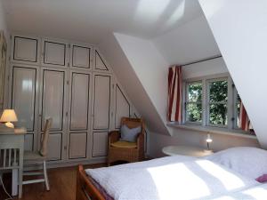 AlkersumFriesentraum的卧室配有床、椅子和窗户。