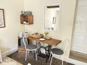 凯尔苏斯Y Felin Bed and Breakfast and Smallholding的配有一张桌子、两把椅子和一面镜子的房间