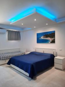 卡梅拉诺IL CUORE DEL CONERO - CASALE CON PISCINA, Natura e Relax的一间卧室设有一张床和蓝色的天花板