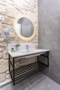 阿菲托斯Anna Mare Luxury Apartments的一间带水槽和镜子的浴室