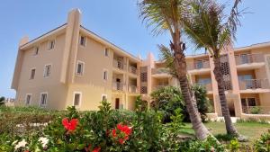 圣玛丽亚Sunset house Cabo Verde的一座棕榈树和鲜花的大型公寓楼