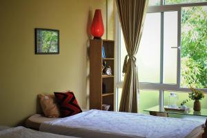 顺化顺化山坡民宿的一间卧室设有一张床和一个窗口